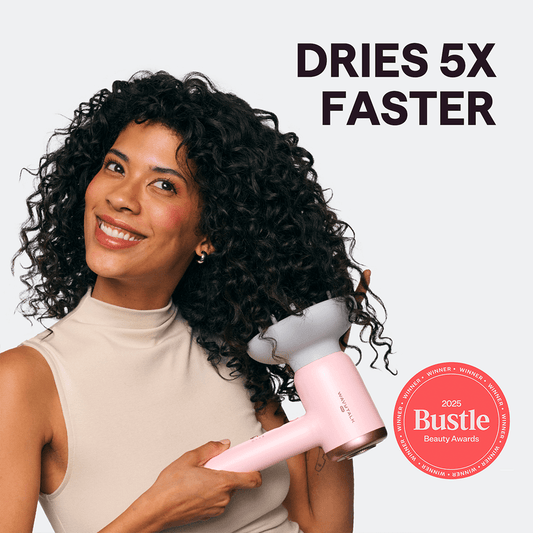 Woman with curly hair holding a pink Turblow Pro hair dryer with 'Dries 5x Faster' text and Bustle Beauty Award badge.