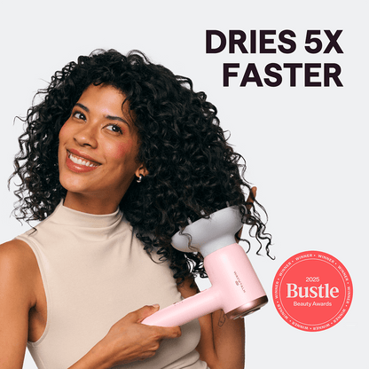 Woman with curly hair holding a pink Turblow Pro hair dryer with 'Dries 5x Faster' text and Bustle Beauty Award badge.